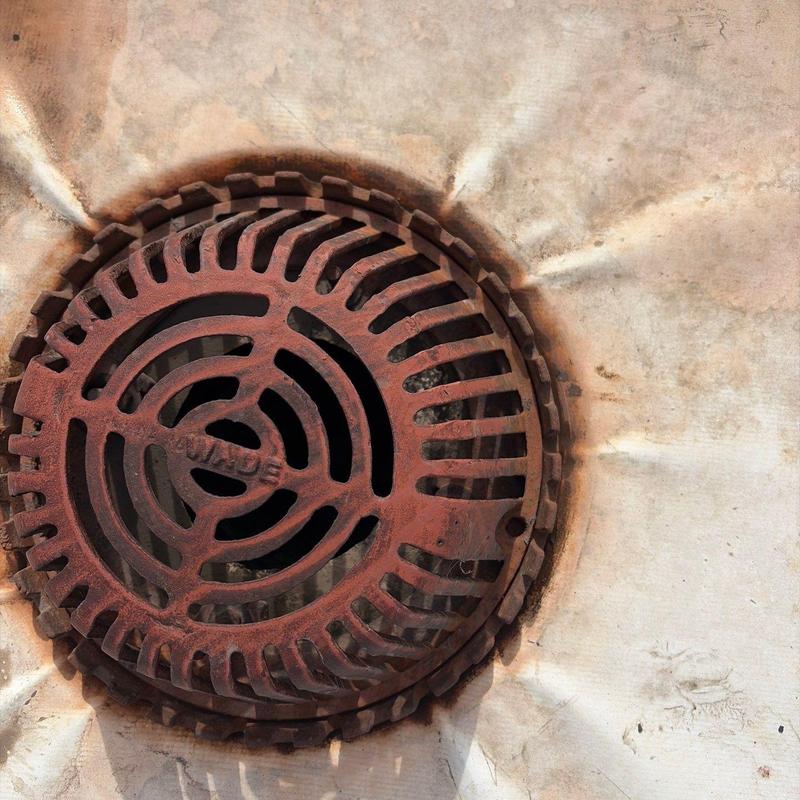 Single ply roof drain with rusted metal grate