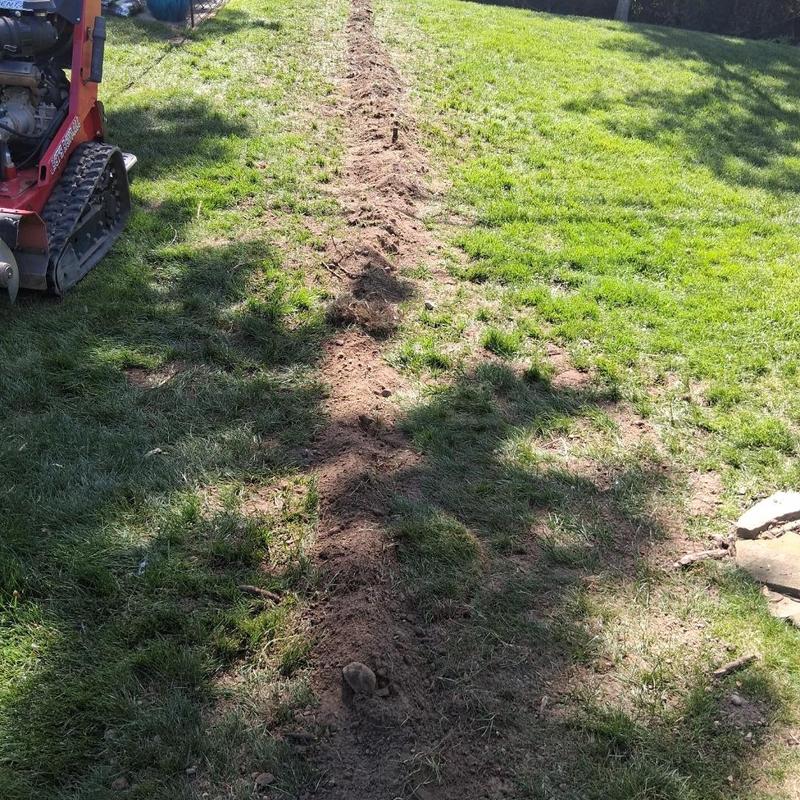 Sump pump discharge line trench excavation in lawn