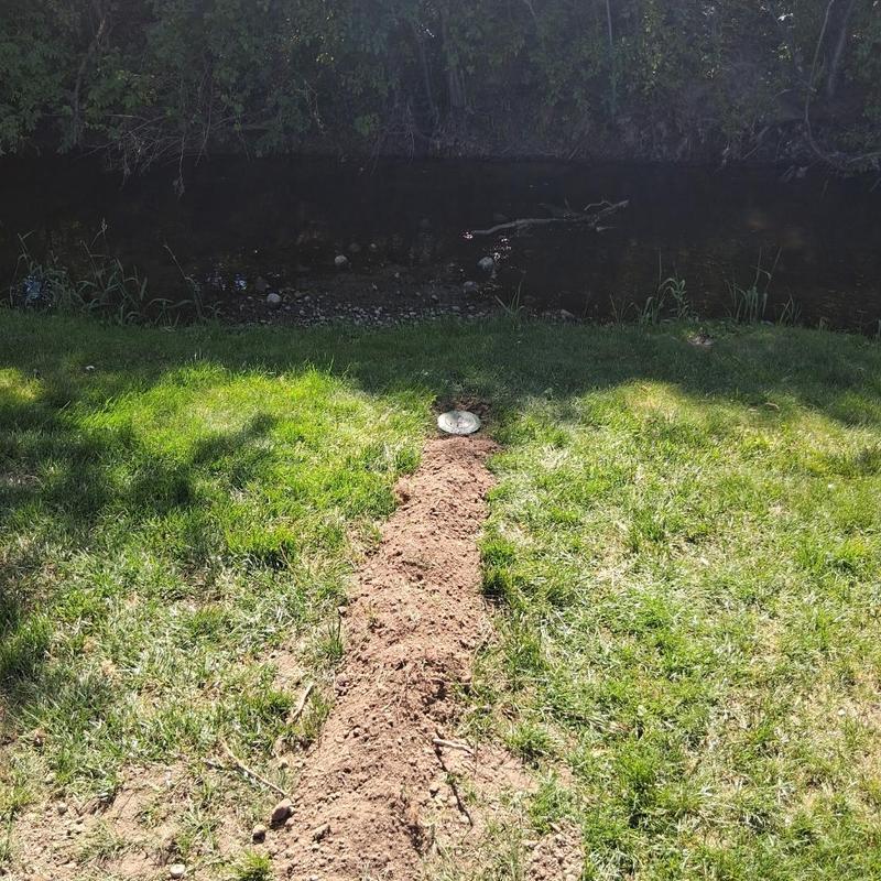 Sump pump discharge line with fresh dirt trench