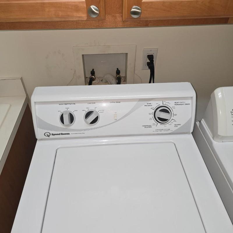 Washer supply lines and bibs behind laundry machine