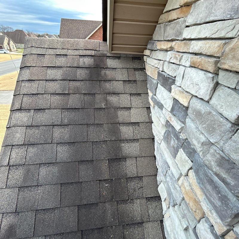 Asphalt shingle roof hail damage near stone siding