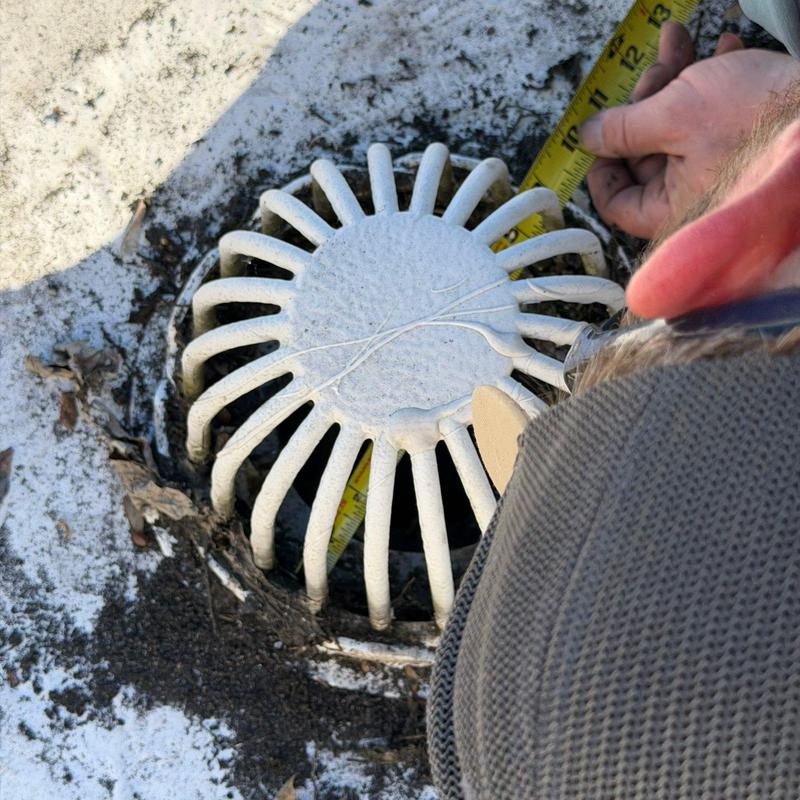 TPO roofing drain cover inspection with measuring tape