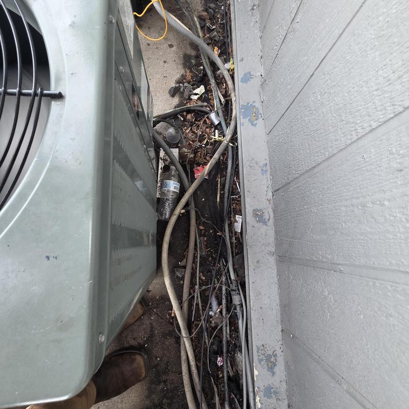 Air conditioner unit 552E with tangled wiring and debris Air conditioner unit 552E with tangled wiring and debris