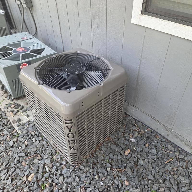 York condenser unit outdoors on gravel near wall York condenser unit outdoors on gravel near wall