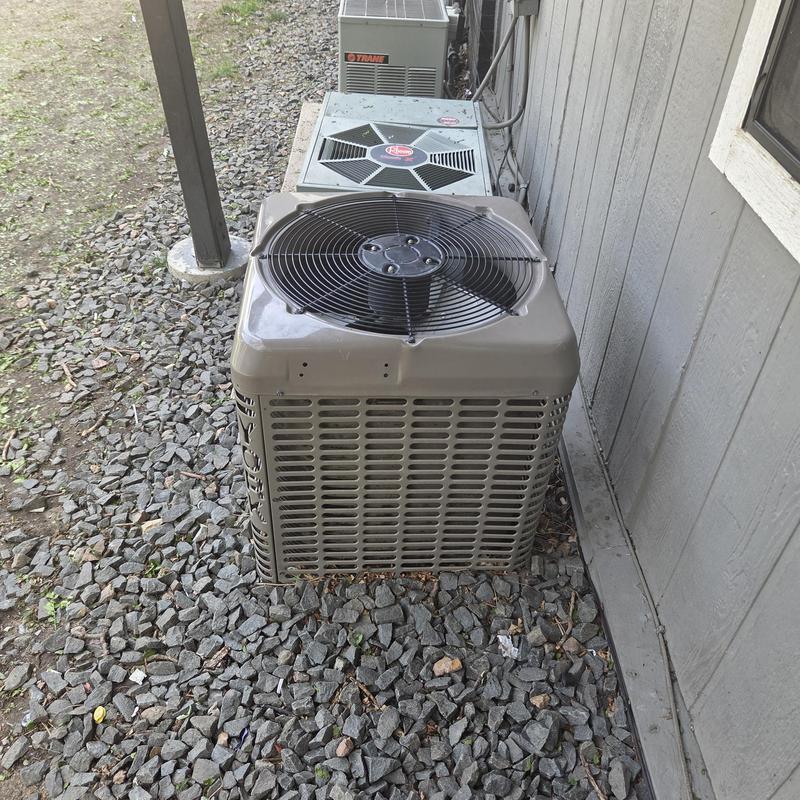 HVAC condenser unit beside a residential building HVAC condenser unit beside a residential building