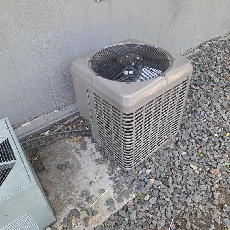 Condenser unit beside house on gravel base Condenser unit beside house on gravel base