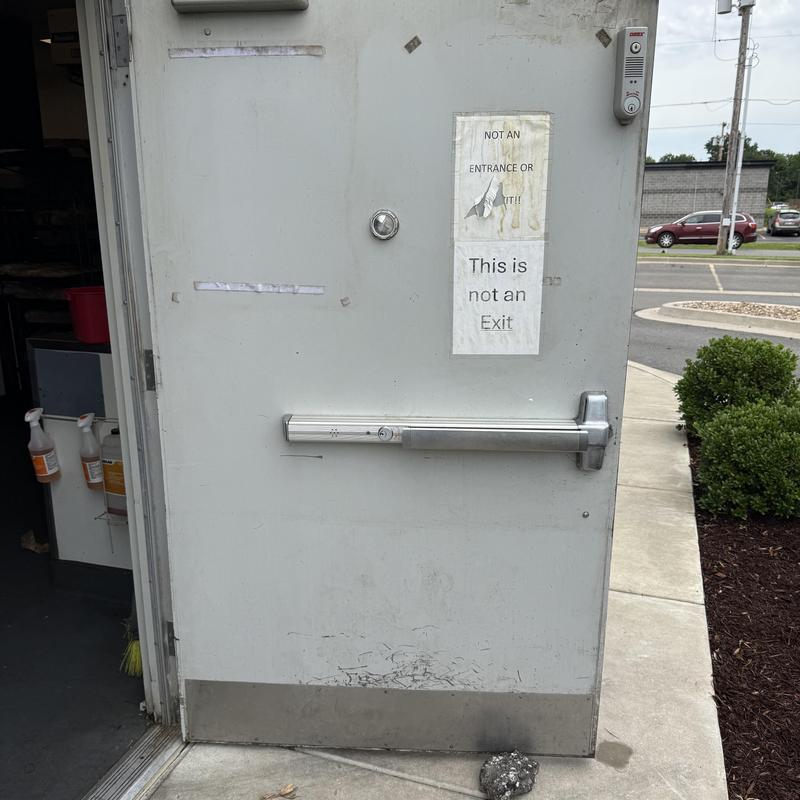 Restaurant delivery door with damaged hinges and latch bar