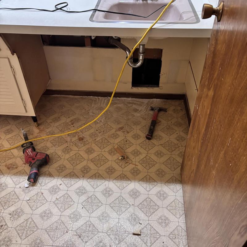 Kitchen sink plumbing repipe with tools on floor