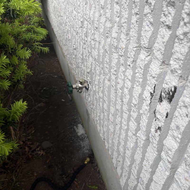 Outside faucet installation on church building exterior wall