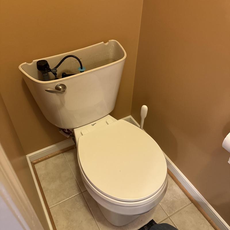 Toilet tank with exposed interior parts in bathroom Toilet tank with exposed interior parts in bathroom