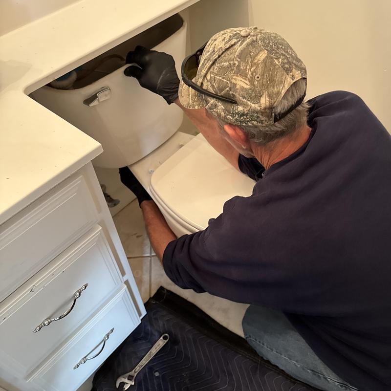 Toilet tank removal and reset by plumber in bathroom Toilet tank removal and reset by plumber in bathroom