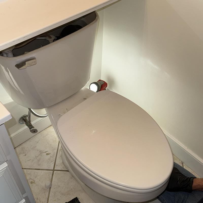Toilet tank with pulled lid and nearby flashlight Toilet tank with pulled lid and nearby flashlight