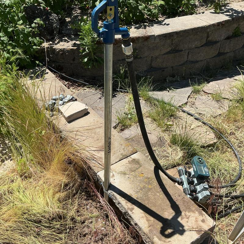 Yard hydrant installation with connected hose and pump
