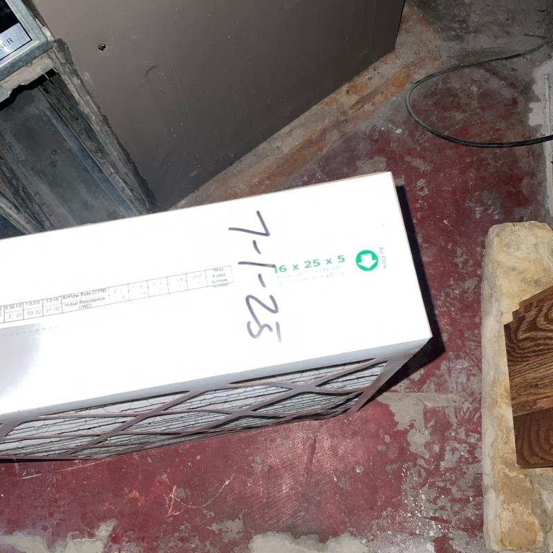 HVAC air filter on red concrete floor near furnace