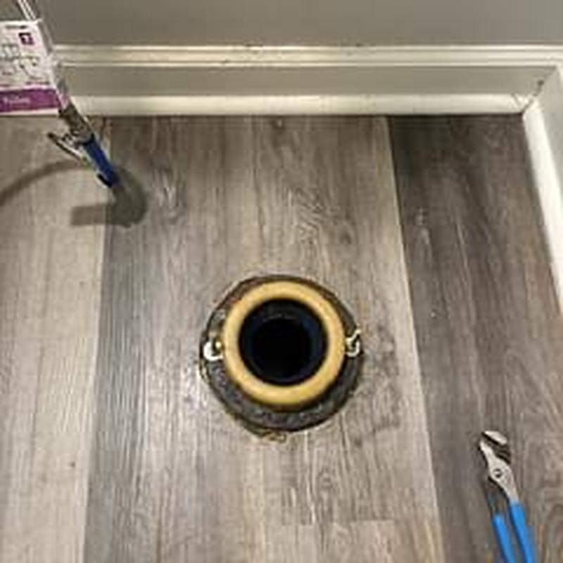 Toilet flange with drain cleaning tools on floor