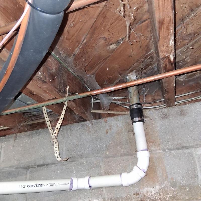 Copper water piping and PVC drain line in crawl space