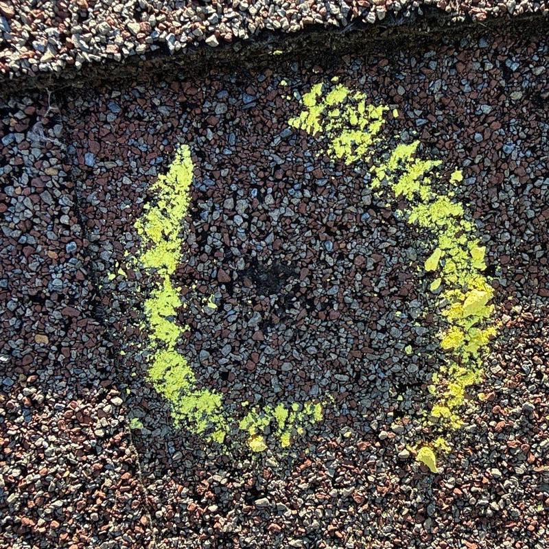 Asphalt shingle hail damage marked for inspection