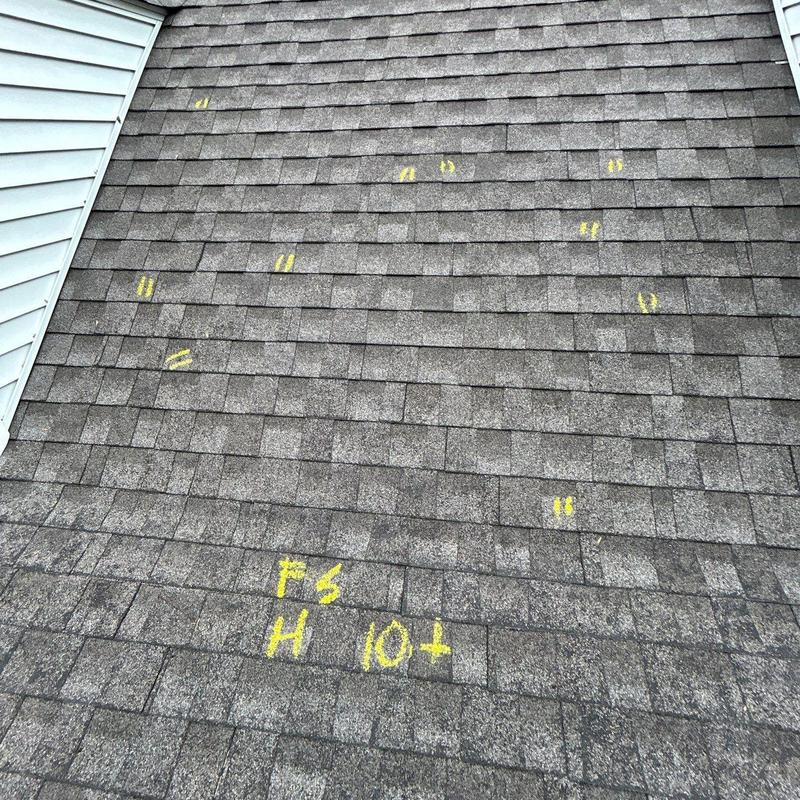 Asphalt shingles with hail damage markings on roof