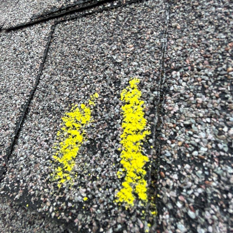 Asphalt shingle hail damage marked in yellow paint