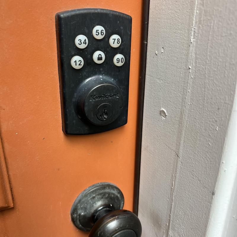 Electronic keypad lock on orange door in Tulsa