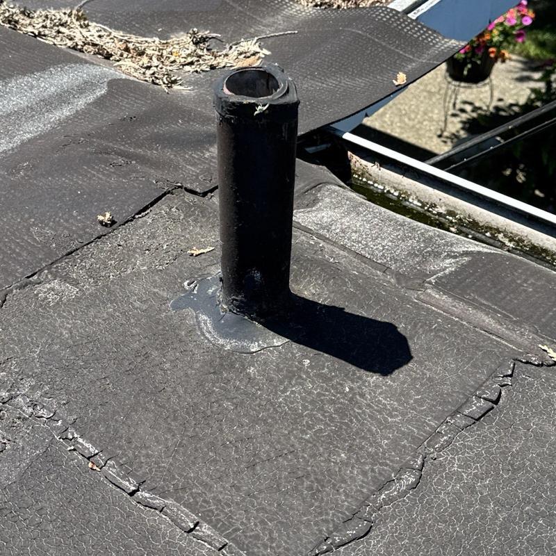 Roof vent pipe flashing with cracked roofing membrane