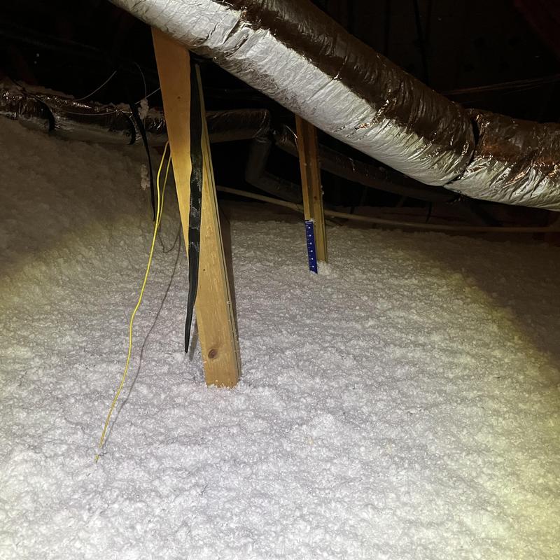 Attic blown-in insulation with ductwork and wooden supports