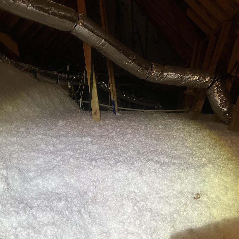 Attic insulation with ductwork in wooden attic space