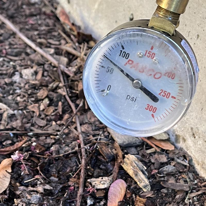 Pressure gauge on plumbing system near ground