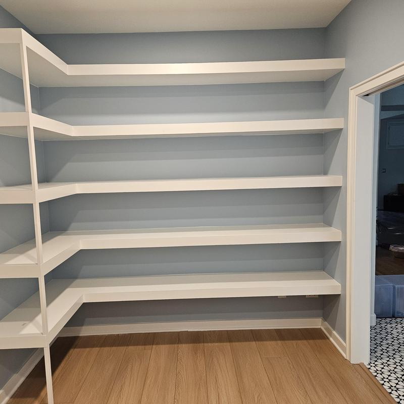 Corner wall-mounted white shelving in home remodel Corner wall-mounted white shelving in home remodel