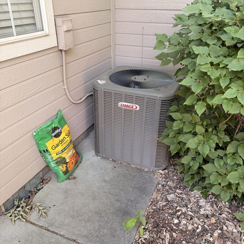 Lennox outdoor air conditioning condenser unit near shrubbery Lennox outdoor air conditioning condenser unit near shrubbery