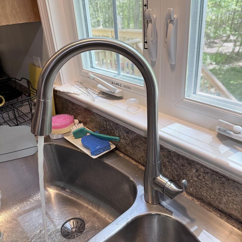 Kitchen faucet with water running over sink