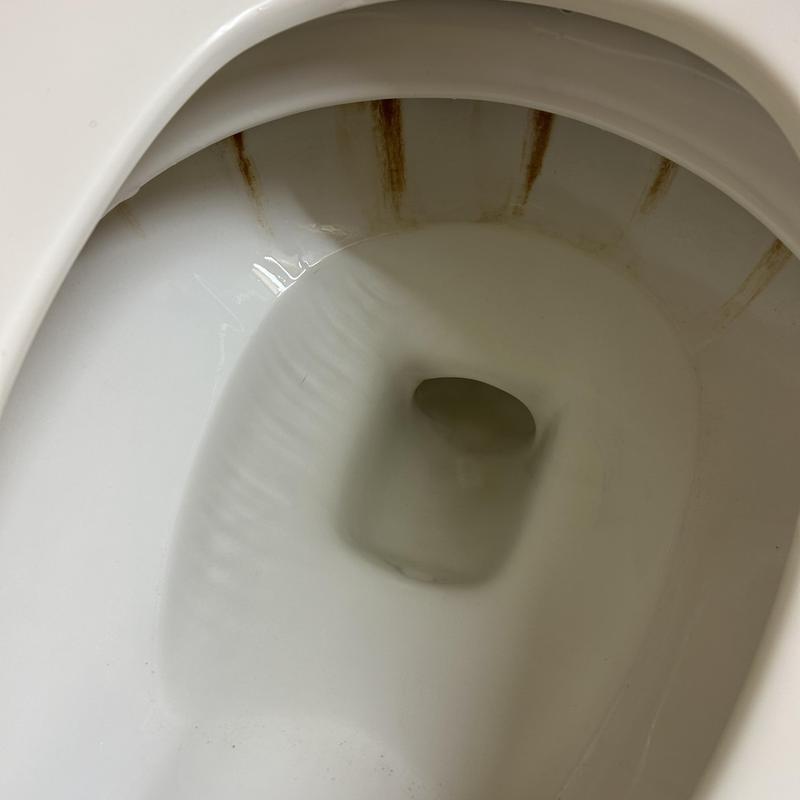 Toilet bowl with rust stains inside porcelain rim Toilet bowl with rust stains inside porcelain rim