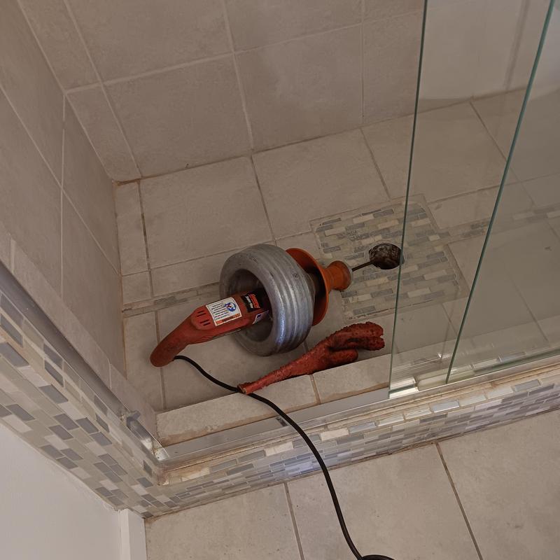 Shower drain clog snake tool inside shower stall