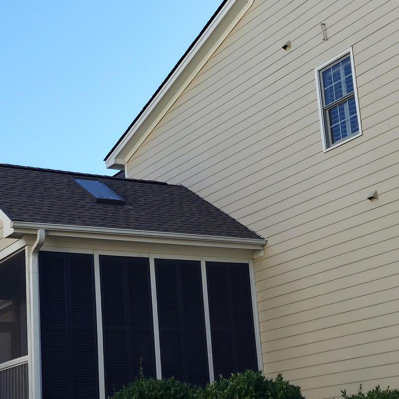 Roof shingles and skylight on residential home exterior Roof shingles and skylight on residential home exterior