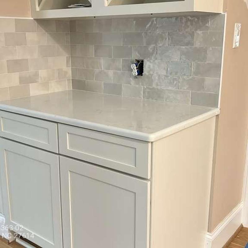 Quartz countertop and tile backsplash installation in kitchen Quartz countertop and tile backsplash installation in kitchen