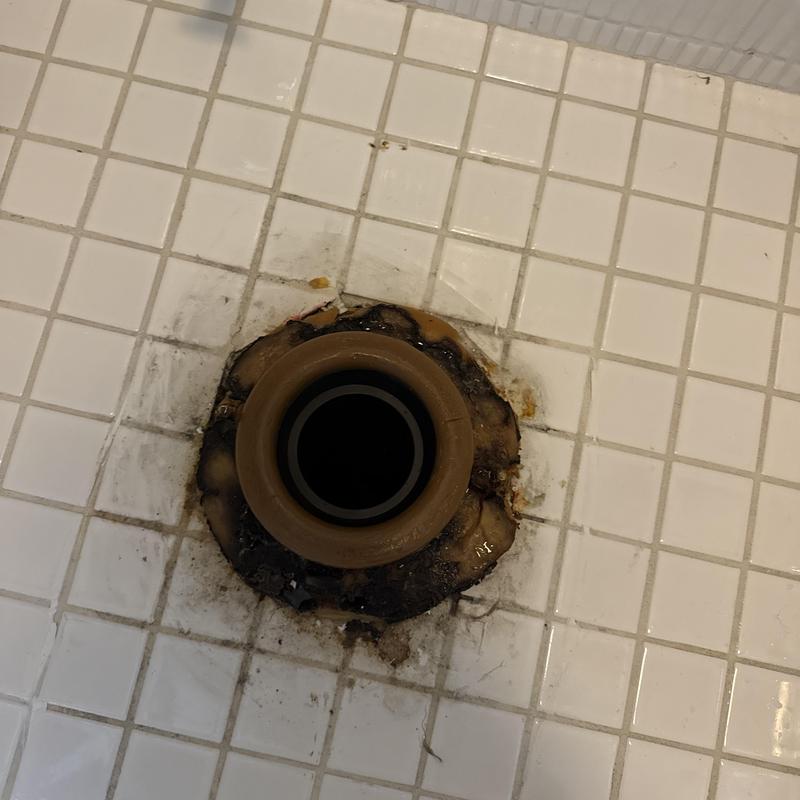 Toilet flange on tiled floor with wax residue