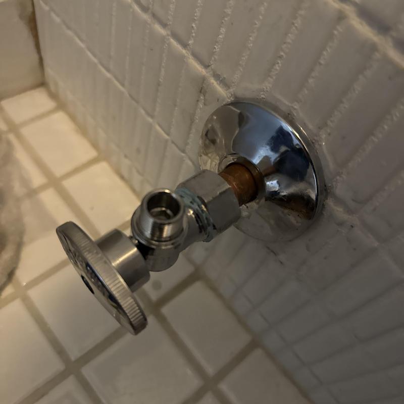 Toilet angle stop valve installed on tiled wall