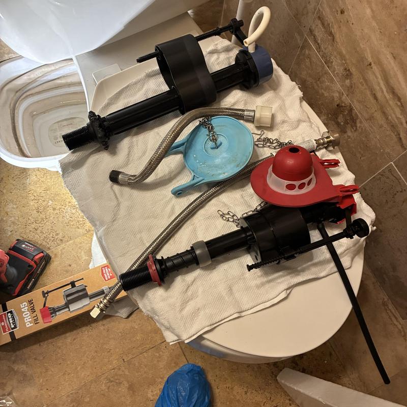 Toilet fill valves and supply line replacement parts on towel