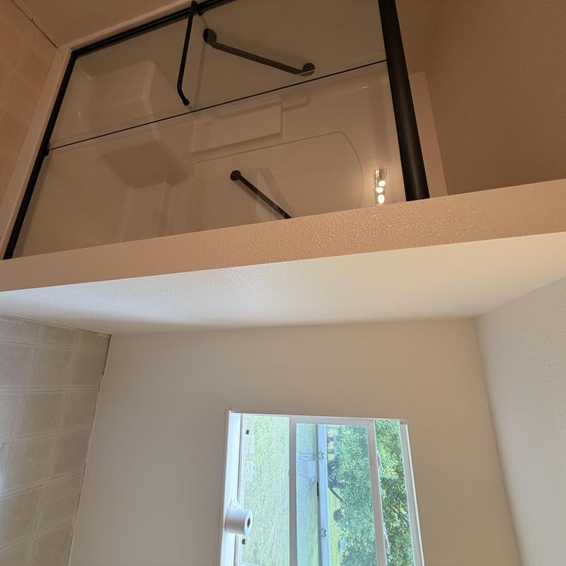 Glass shower enclosure with black frame and door handle