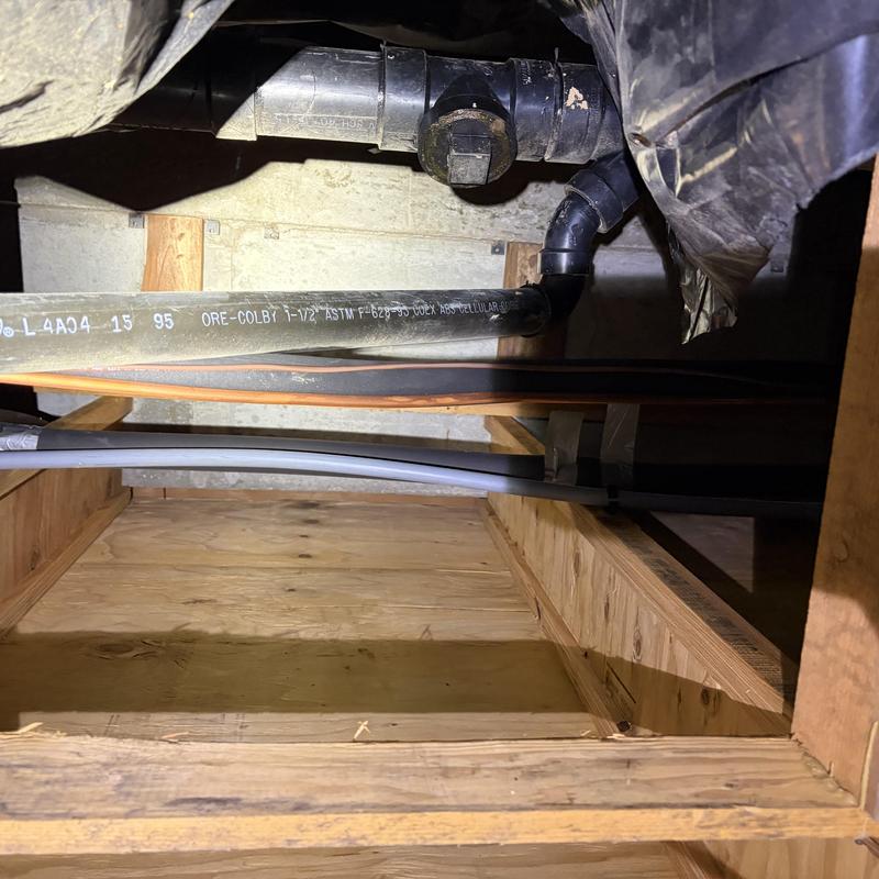 PVC drain pipe fitting with electrical conduit above PVC drain pipe fitting with electrical conduit above