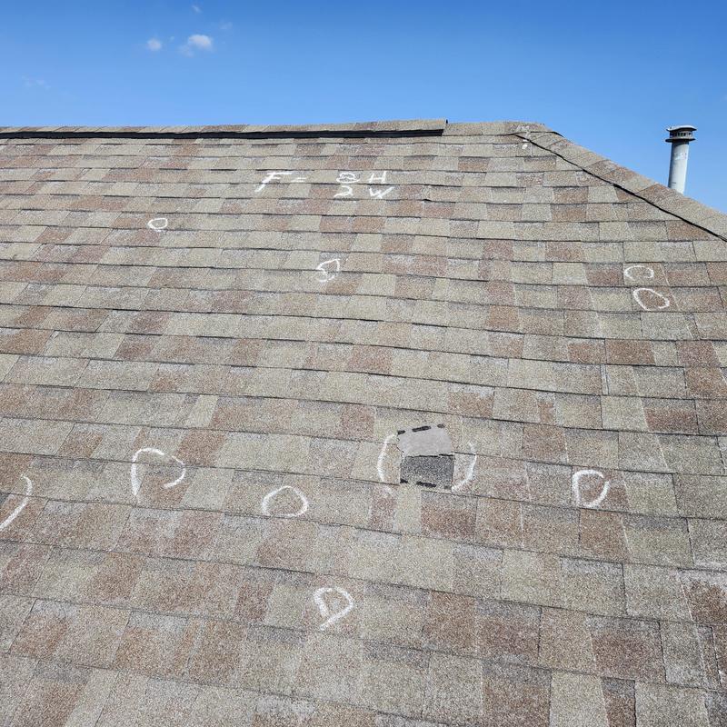 Asphalt shingle roof with marked hail damage spots Asphalt shingle roof with marked hail damage spots