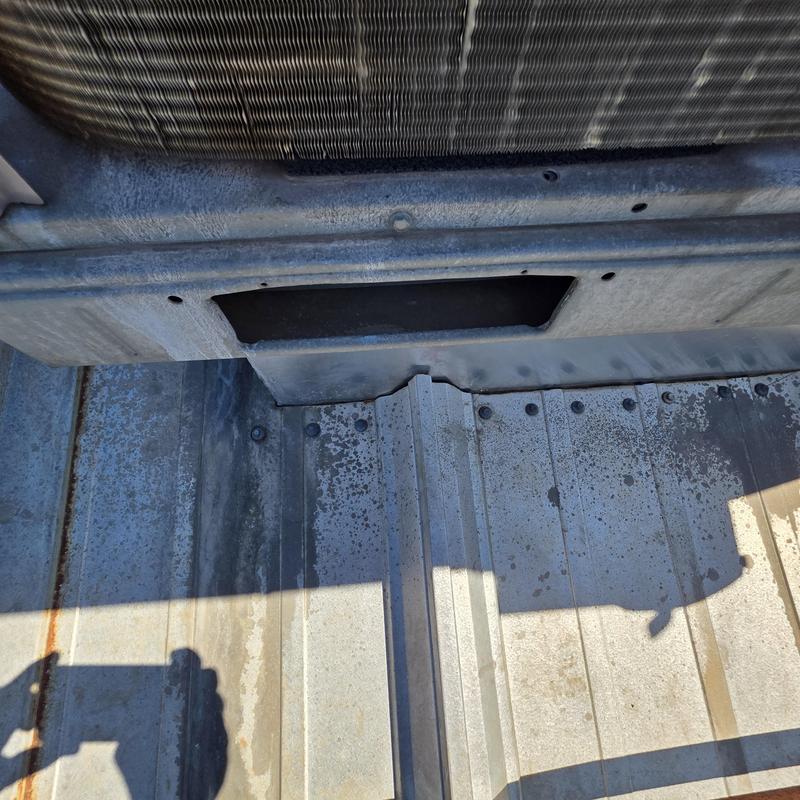 HVAC unit base on metal roof with leak damage