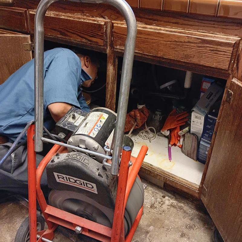 Kitchen drain line with plumbing snake under sink