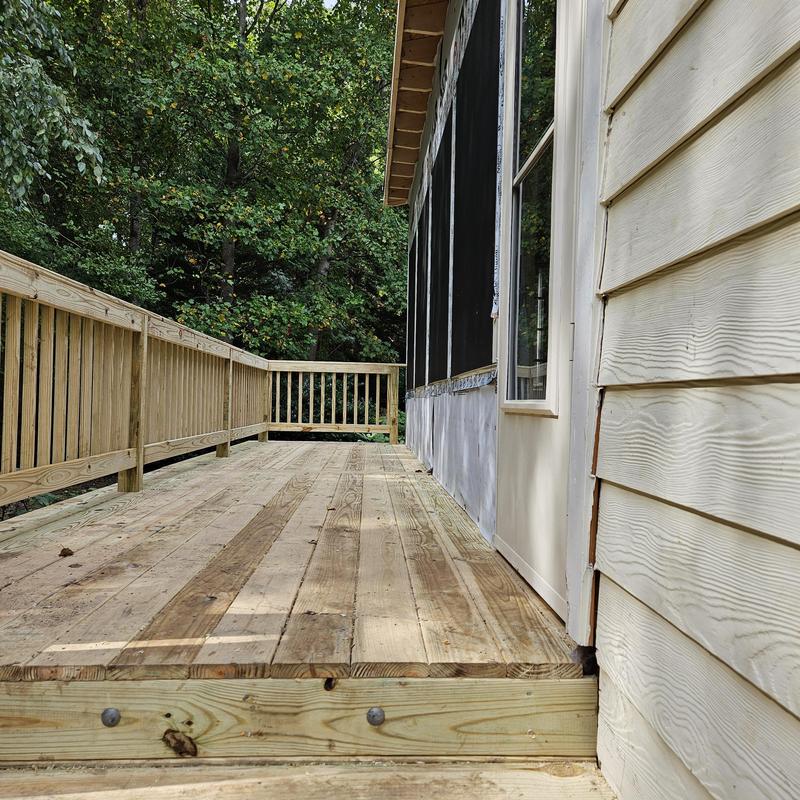 Wooden deck with railing beside house siding Wooden deck with railing beside house siding
