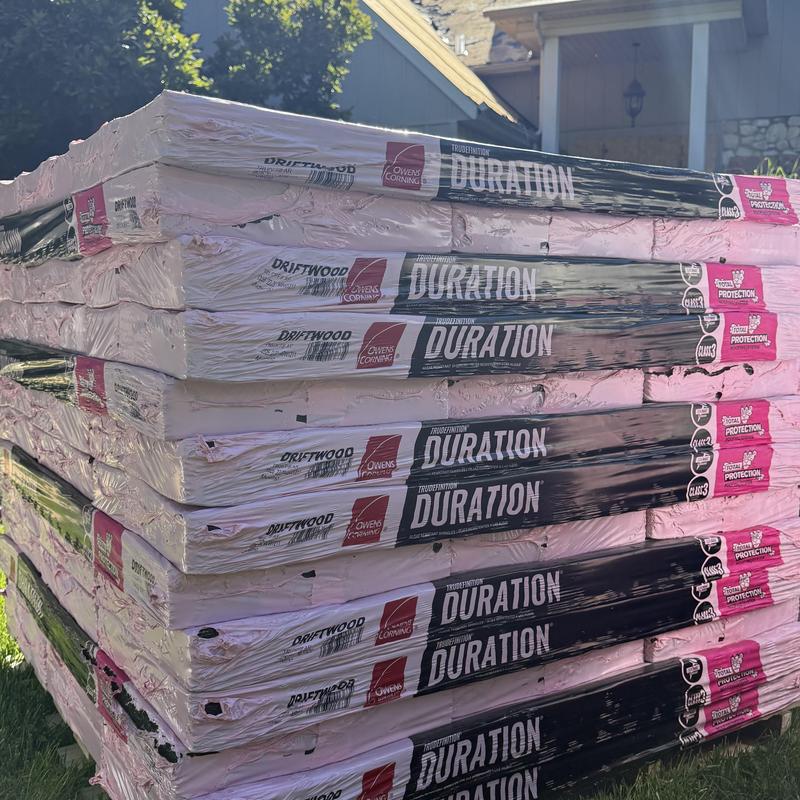 Owens Corning Duration asphalt shingles stack outdoors Owens Corning Duration asphalt shingles stack outdoors