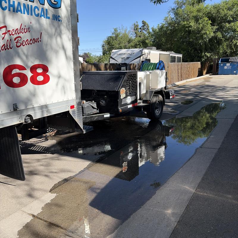 Sewer pipe jetter truck clearing roof vent blockage outdoors Sewer pipe jetter truck clearing roof vent blockage outdoors