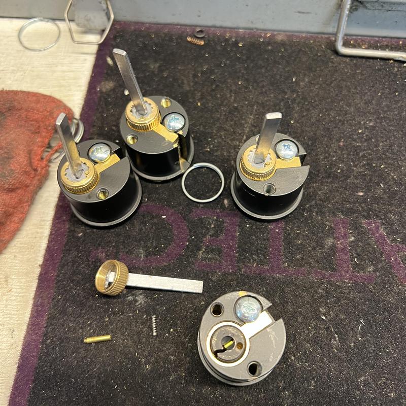 Lock cylinders disassembled for rekeying on mat