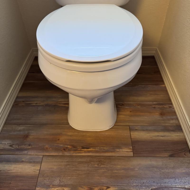 Toilet installation in bathroom with wood flooring Toilet installation in bathroom with wood flooring