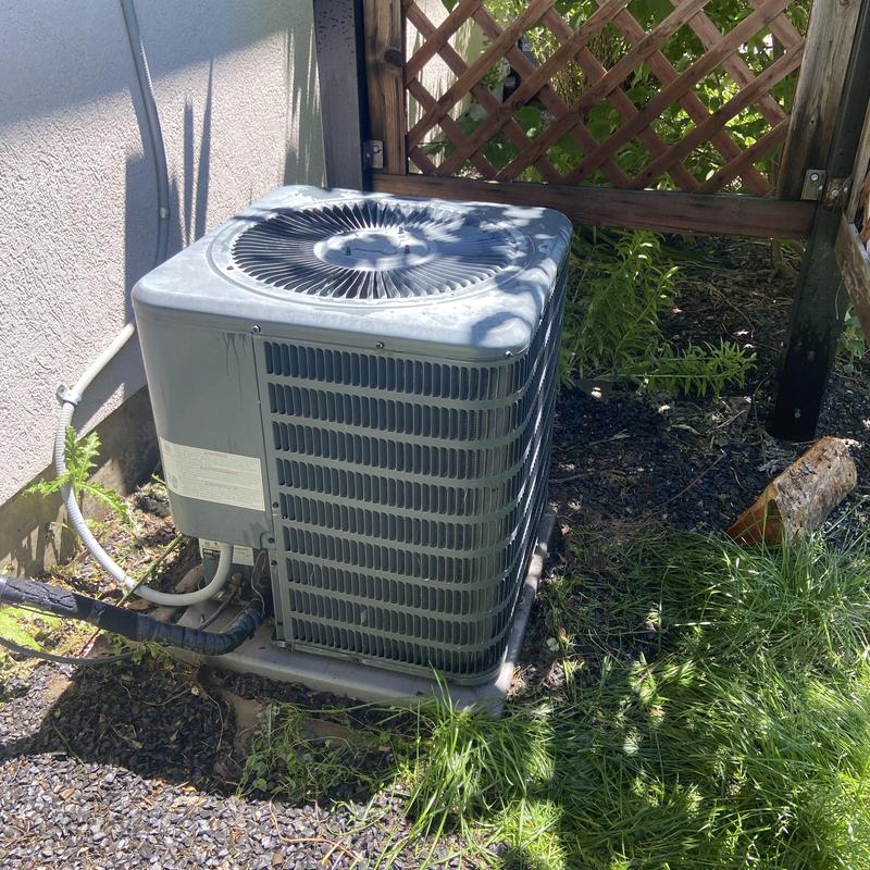 Air conditioner condenser unit beside house and fence Air conditioner condenser unit beside house and fence