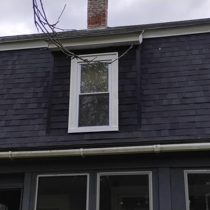 Asphalt shingle roofing with white window trim installation